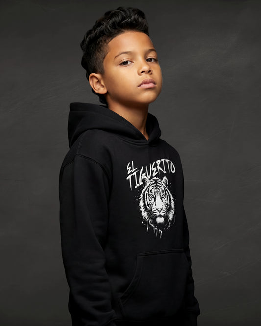 Child wearing a black hoodie with a tiger graphic and text on a dark background