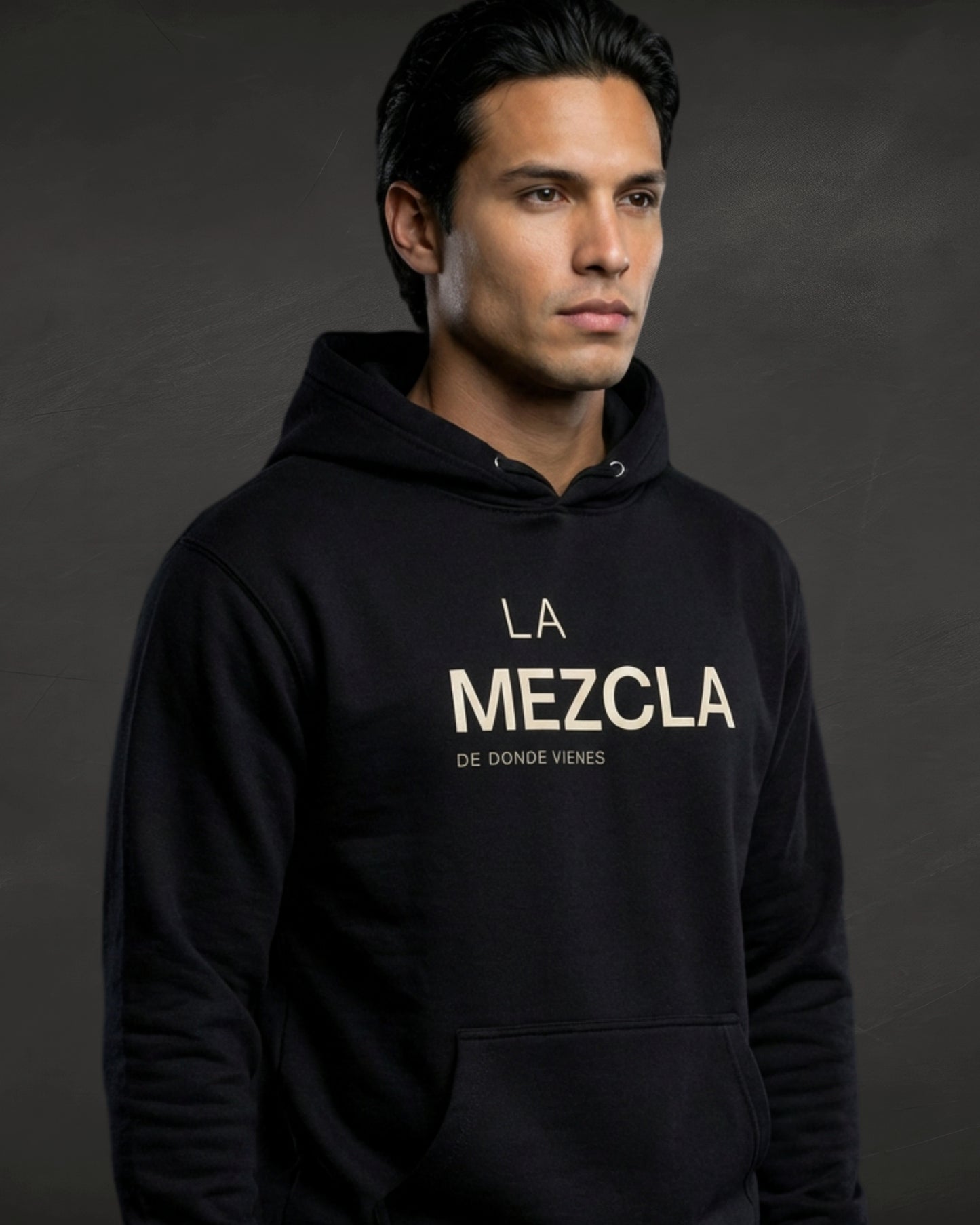 Man wearing a black hoodie with 'La Mezcla' text on a dark background