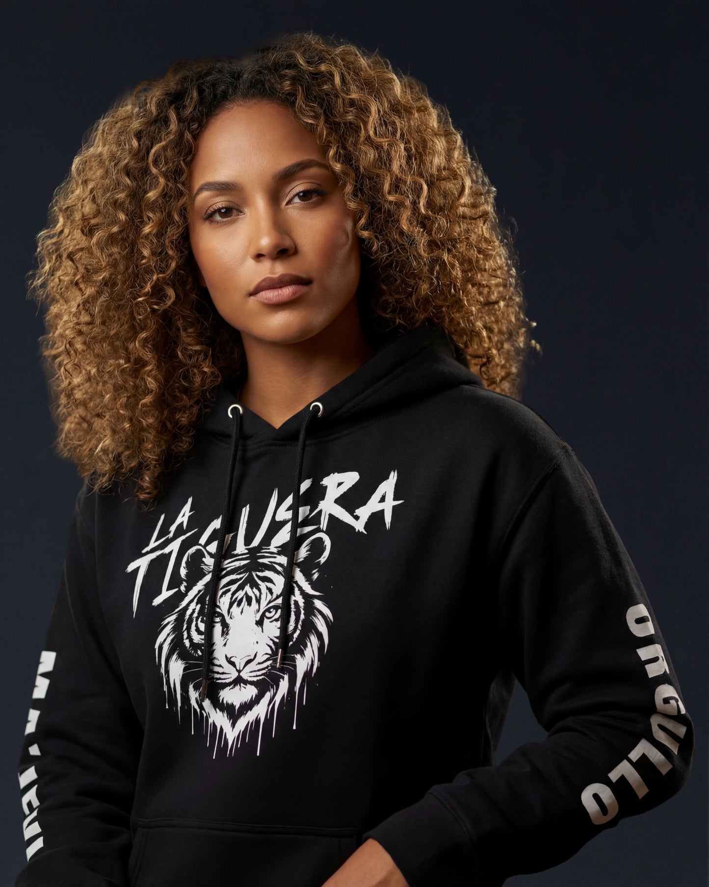 Woman wearing a black hoodie with a tiger design and text on a dark background