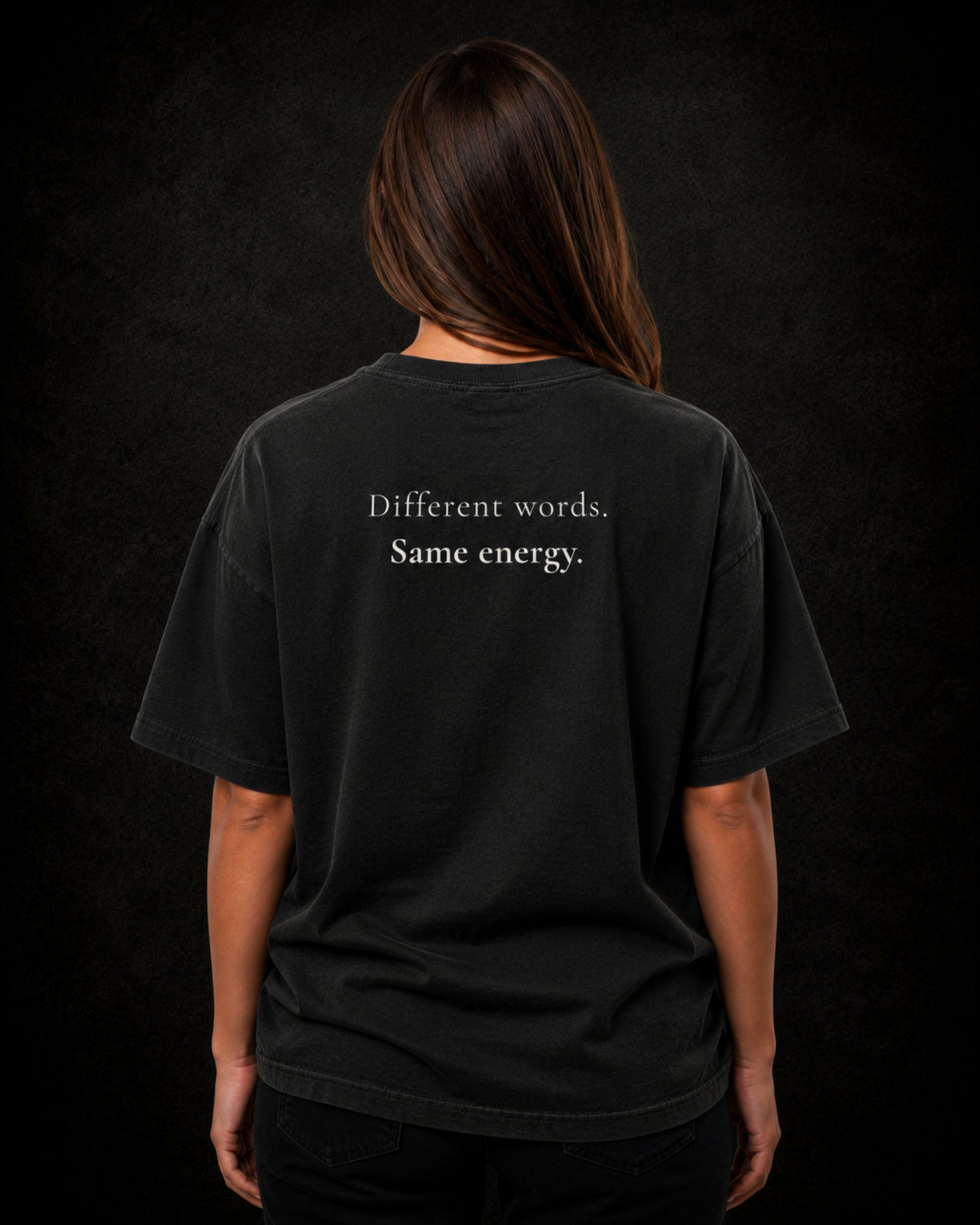 Latina wearing a washed black t-shirt with text on the back against a dark background