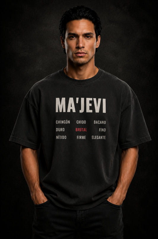 Man wearing a washed black t-shirt with 'MA'JEVI' text on a dark background