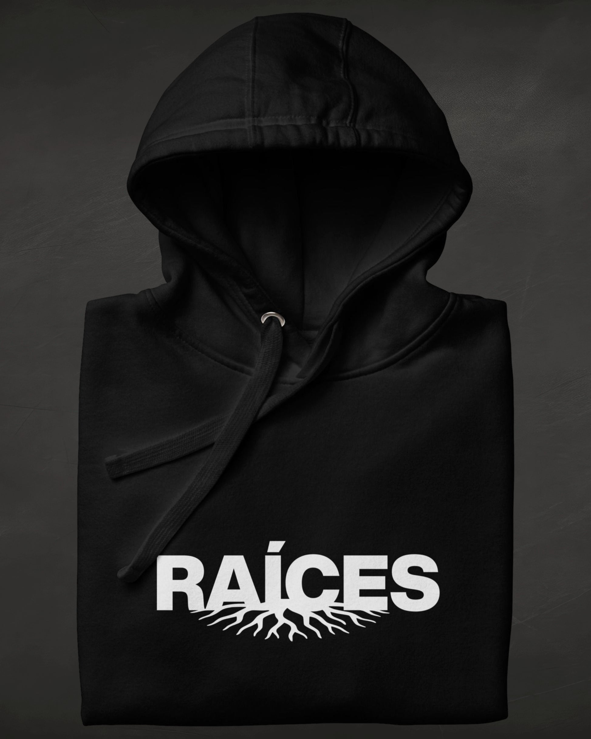 Black hoodie with 'RAÓCES' text and root design on a dark background