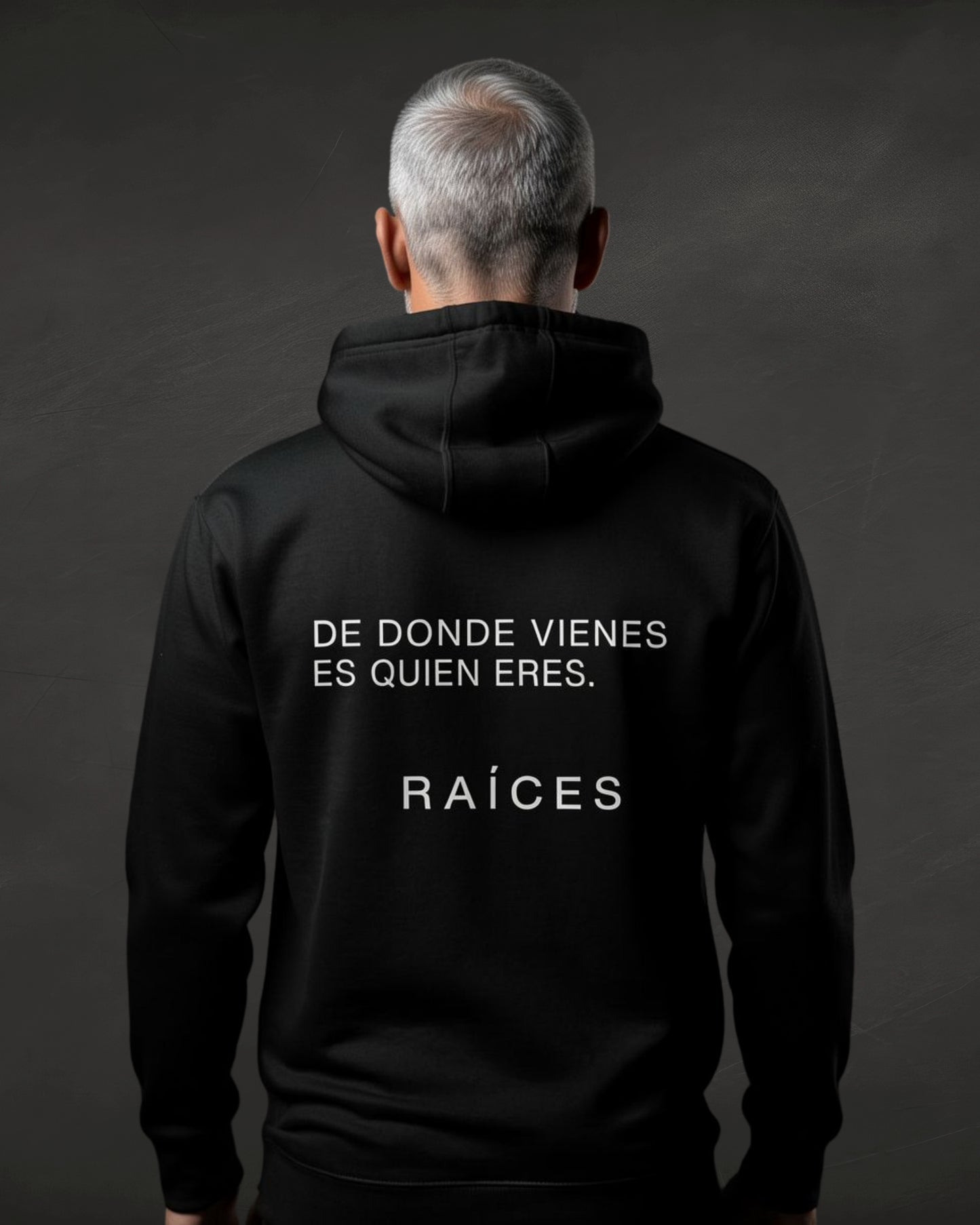 Person wearing a black hoodie with text on the back against a dark background